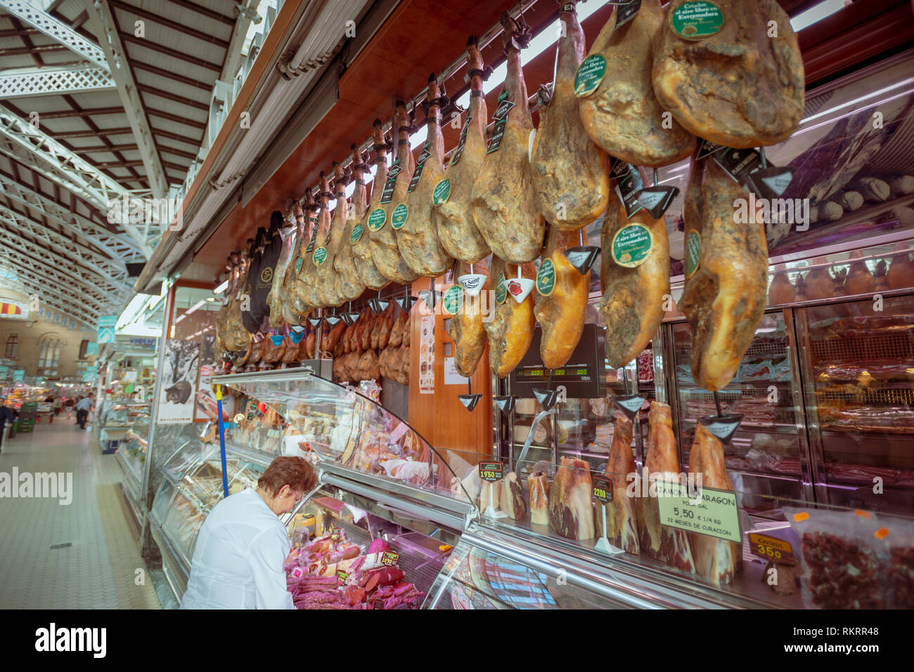 Jamón Serrano - spanischen Schinken, trocken gepökelt, hängend an einem Metzger Markt in der zentralen Markt, Mercado Central, in Valencia, Spanien. Stockfoto