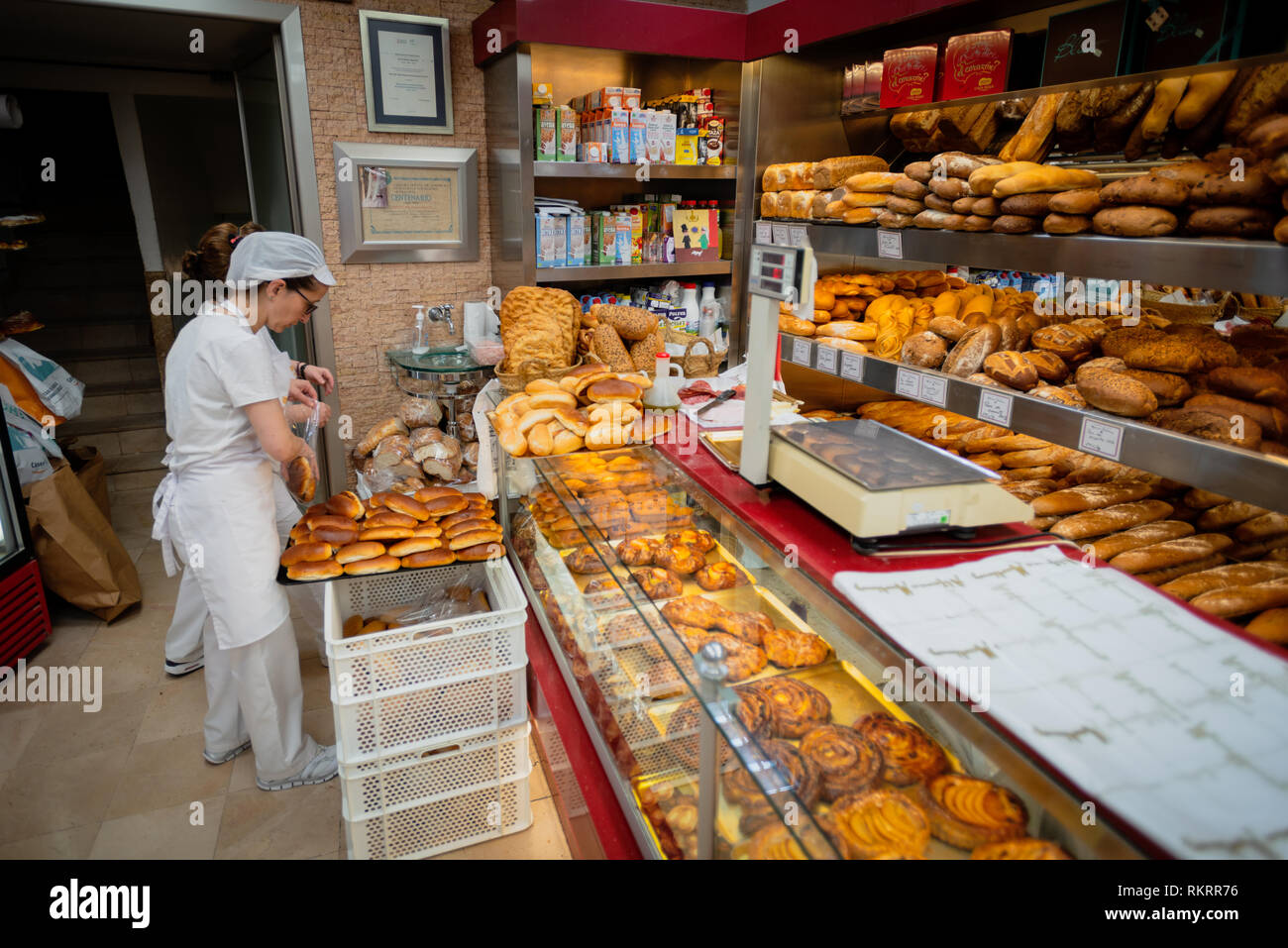 Ein Mitglied des Personals Art frisch gebackenes Brot in einer Patisserie, Konditorei, in der Stadt Valencia, Spanien. Stockfoto