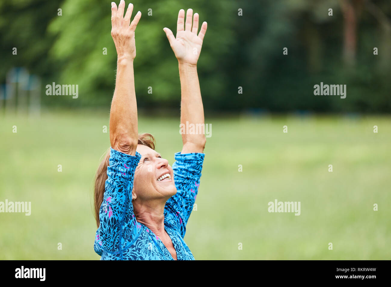 Ältere Frau eine Yoga Übung für Entspannung in der wellness Klasse in der Natur Stockfoto