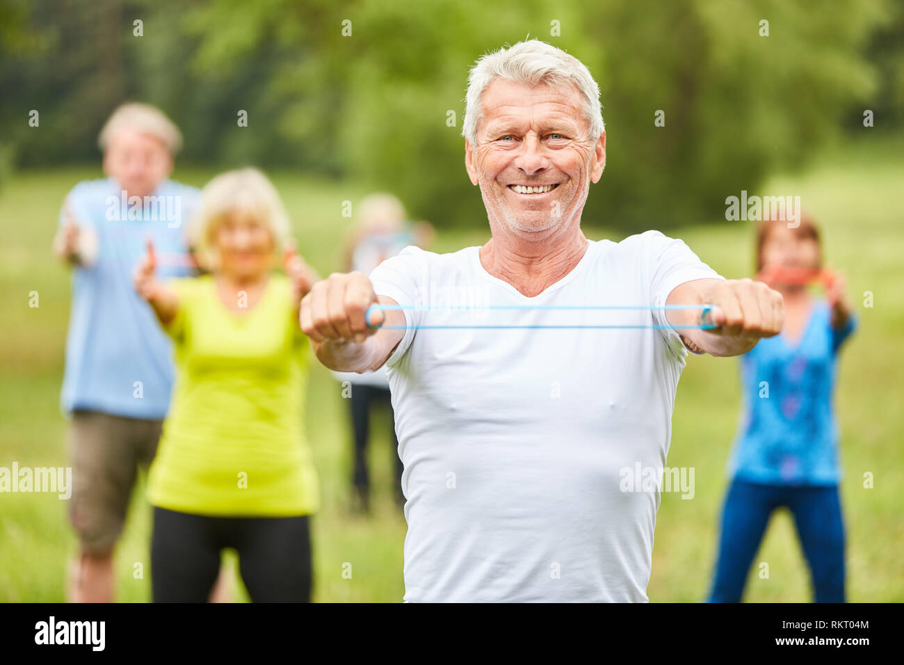 Ältere Menschen Züge mit Stretch band Als Physiotherapie in einer rehab Kurs Stockfoto