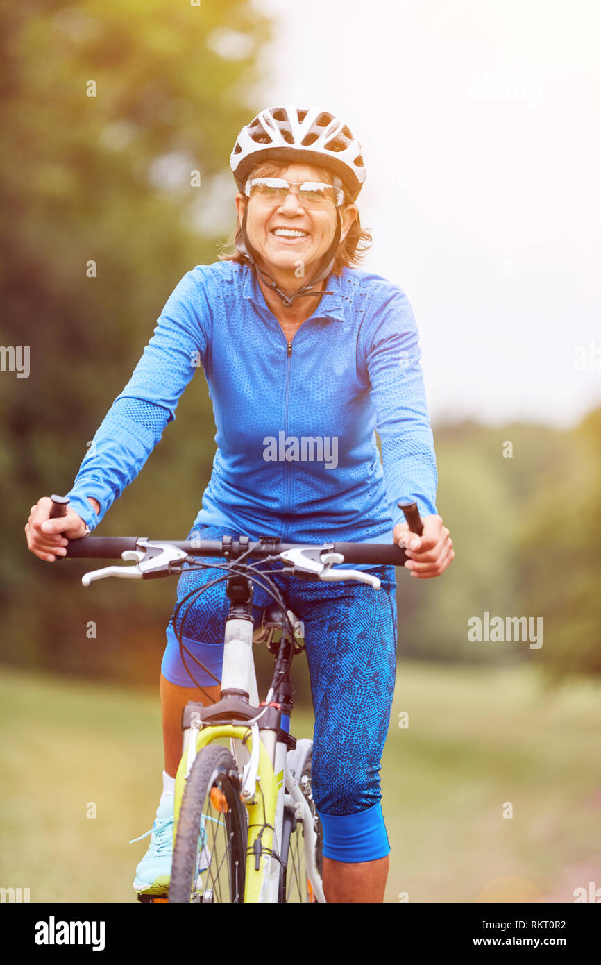 Ältere Frau auf einem Fahrrad mit Mountainbike und Fahrradhelm Stockfoto