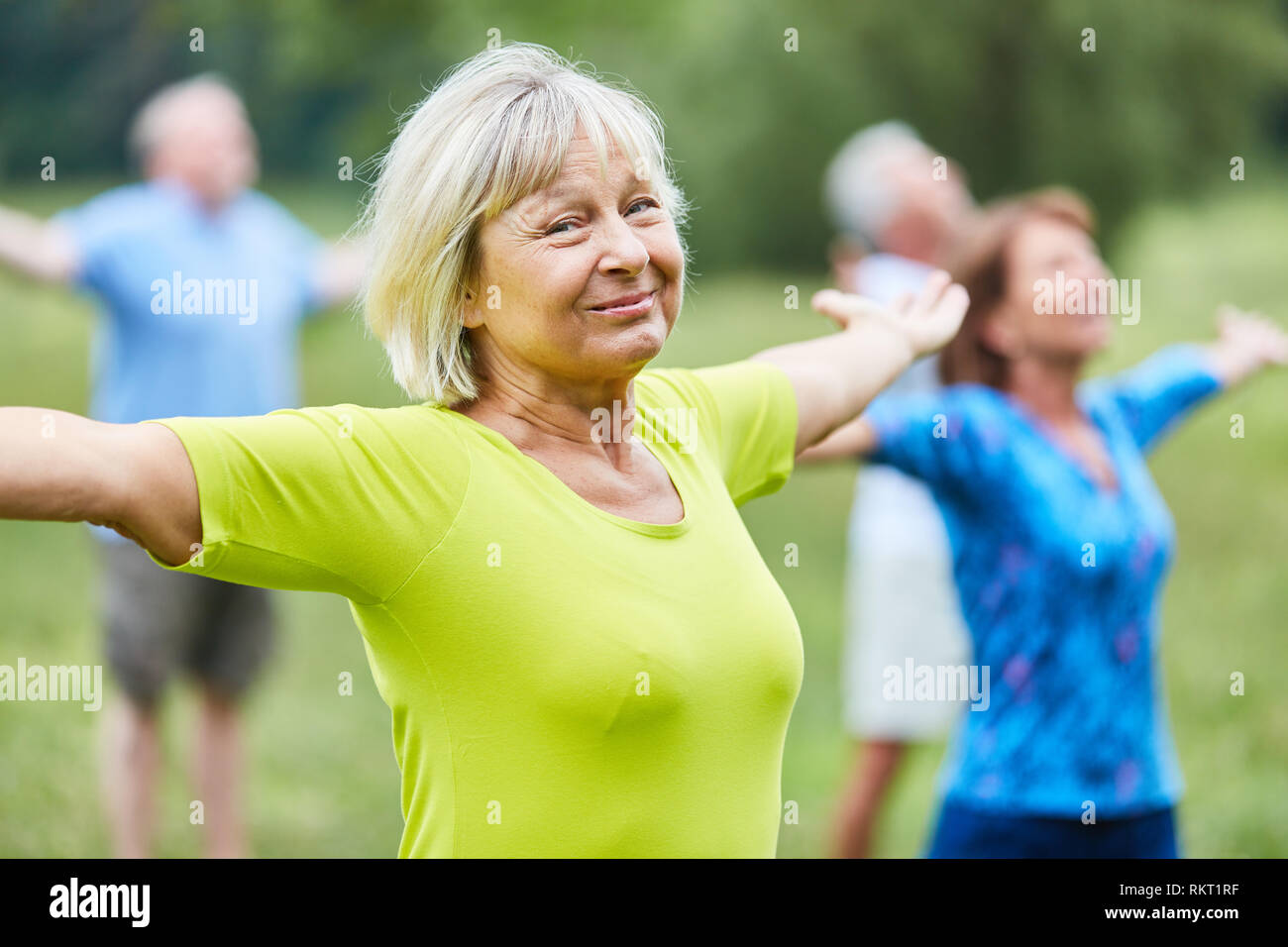 Sportliche Senioren strecken Sie Ihre Arme in einer Wellness Yoga Klasse in rehab Stockfoto