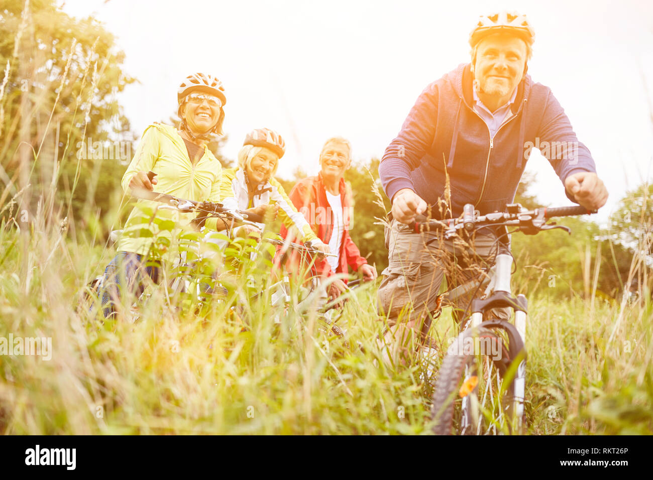 Aktive Gruppe von Seniorinnen und Senioren mit dem Fahrrad gemeinsam Radfahren im Sommer Stockfoto