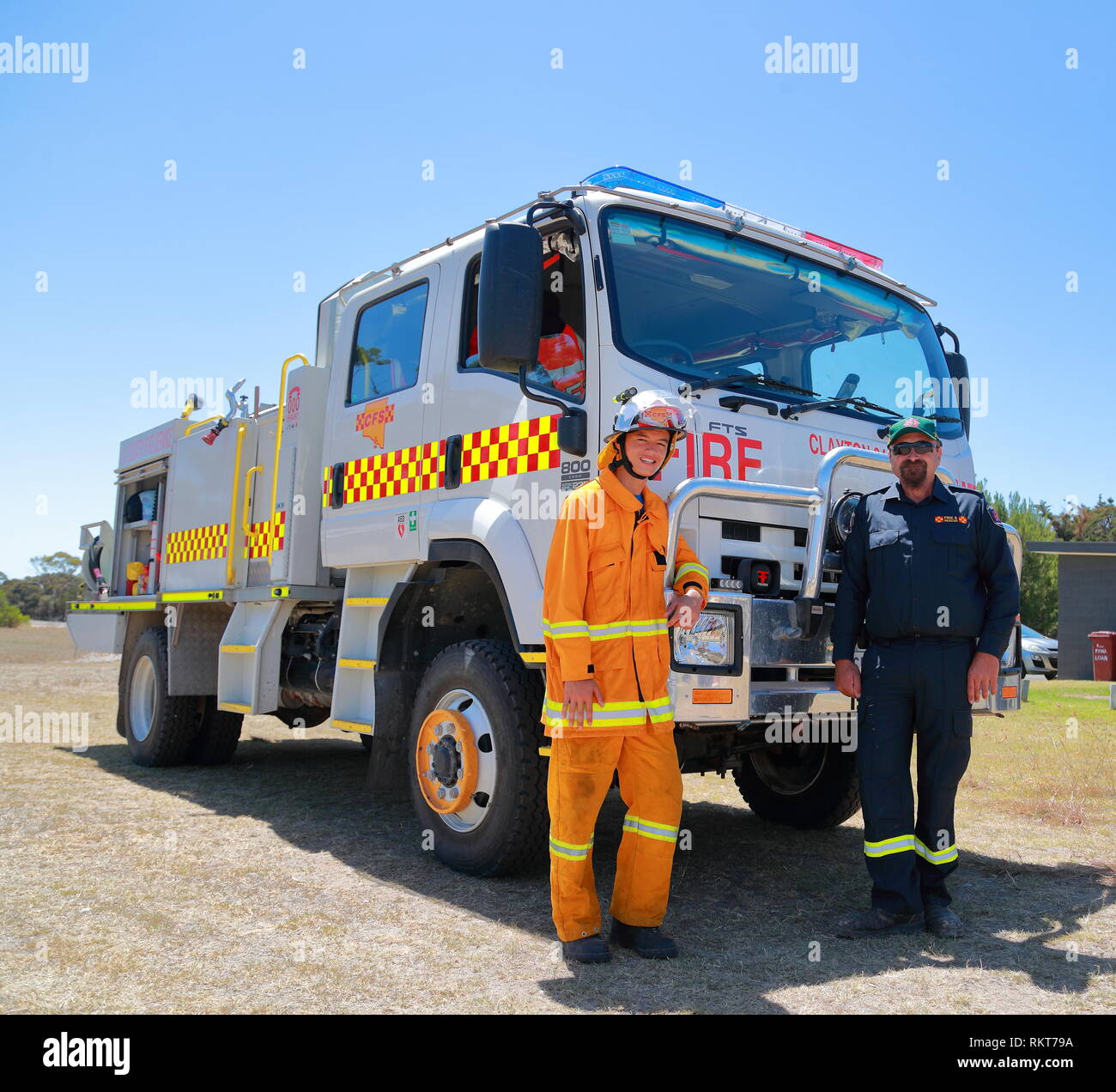 Zwei Feuerwehrleute posieren vor ihrem Isuzu-Feuerwehrauto in Milang, Südaustralien bei der Power Rally in Port Milang, Südaustralien Stockfoto