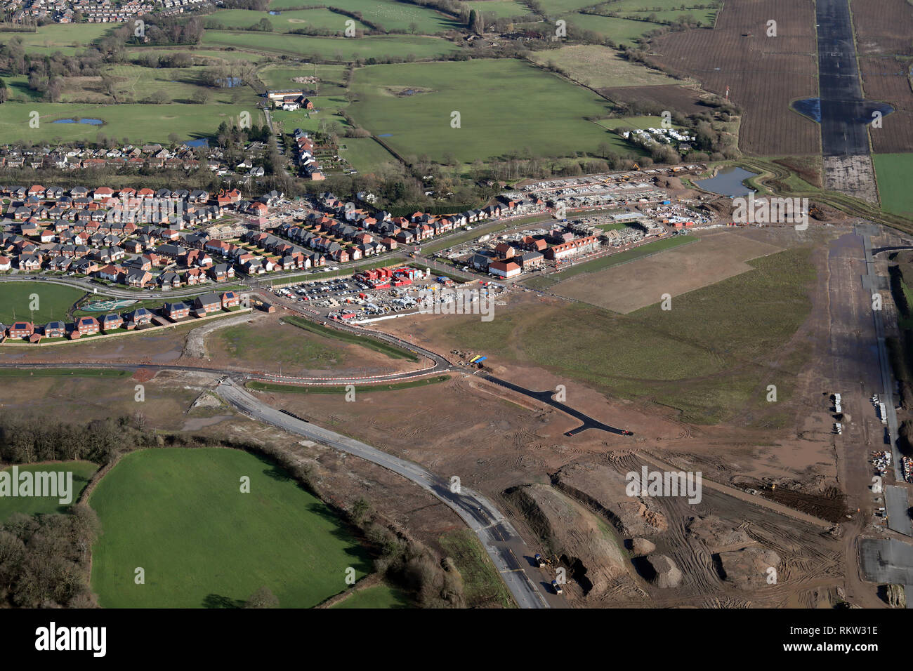 Luftbild der neuen Wohnungen auf braun Wiese an der Woodford Flugplatz gebaut wird, Manchester Stockfoto