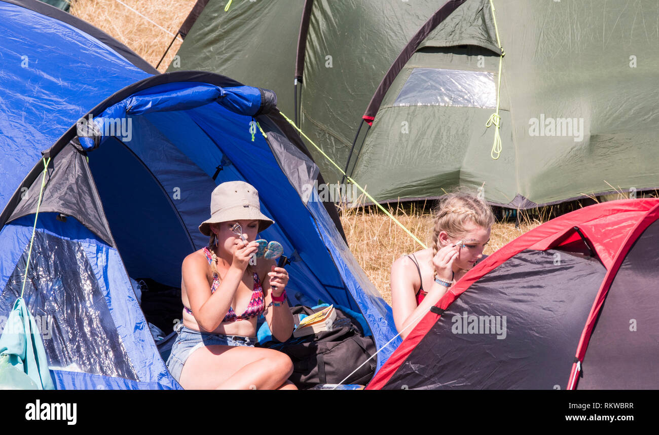 Junge Damen machen Sie sich bereit für den letzten Tag des Festivals im Campingplatz bei Latitude Festival 2018. Stockfoto