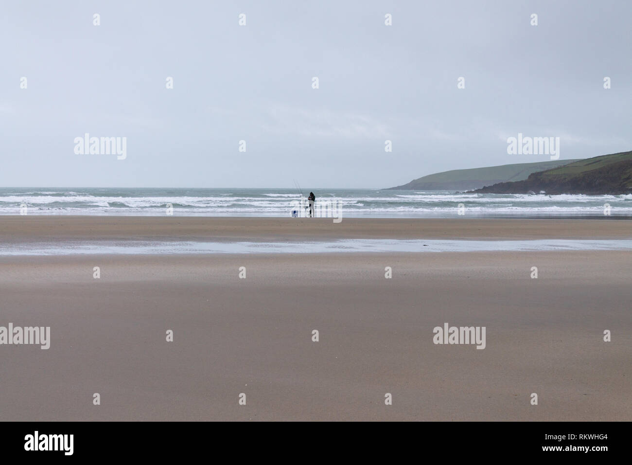 Inchydoney, West Cork, Irland, 12. Februar 2019 Trotz einer beißenden Wind und Nieselregen den ganzen Tag ein einsamer Fischer Sean Og McShane, die Irland in Wettbewerben vertreten hat, versucht sein Glück Angeln für Bass auf Inchydoney Strand. Stockfoto