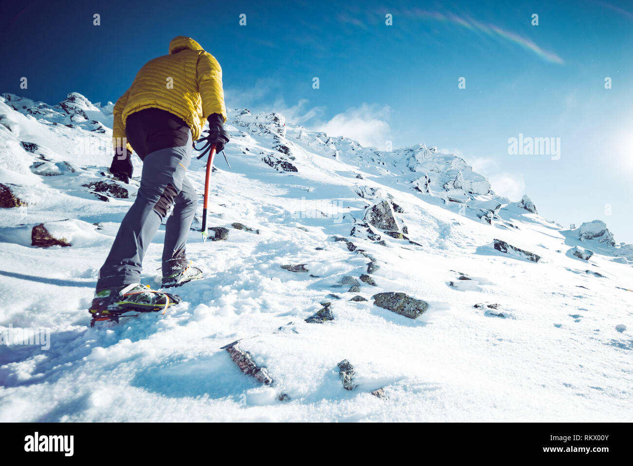 Ein Bergsteiger aufsteigend ein Berg im Winter Stockfoto