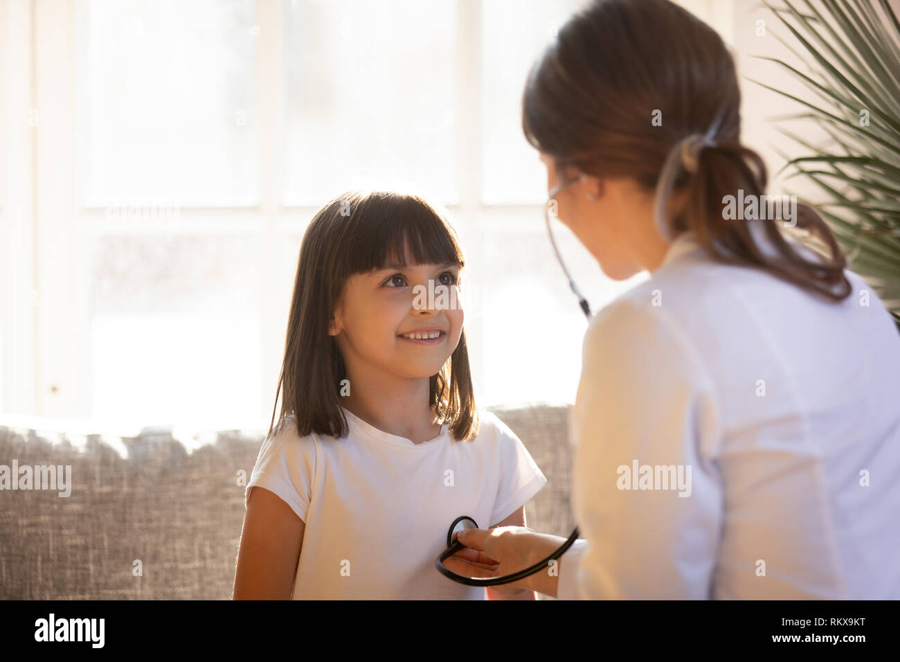Cute kid Besuch weiblicher Arzt Kinderarzt holding Stethoskop Prüfung Kind Stockfoto