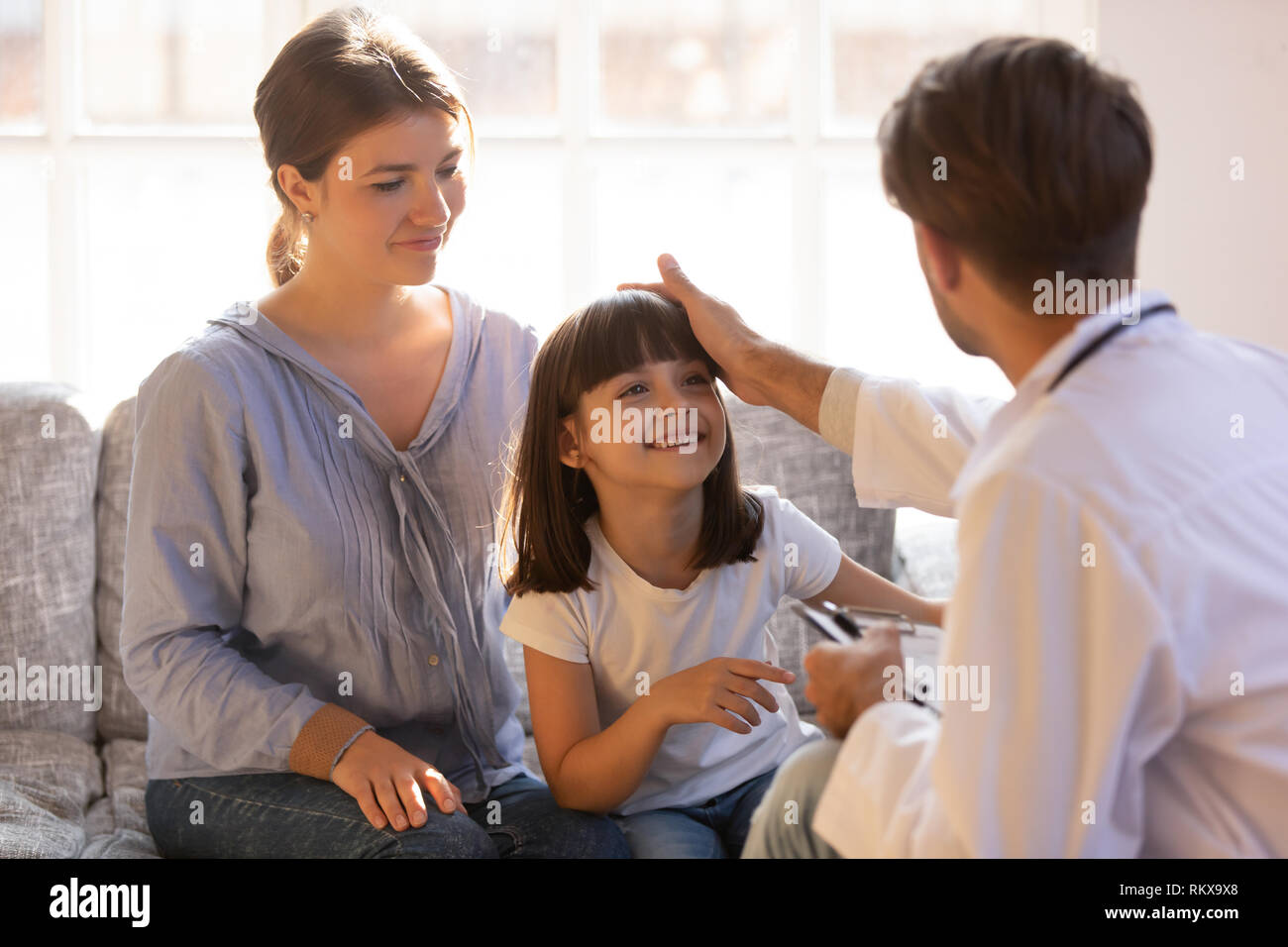 Pflege männlicher Arzt streicheln Kopf des kleinen Mädchens patient Stockfoto