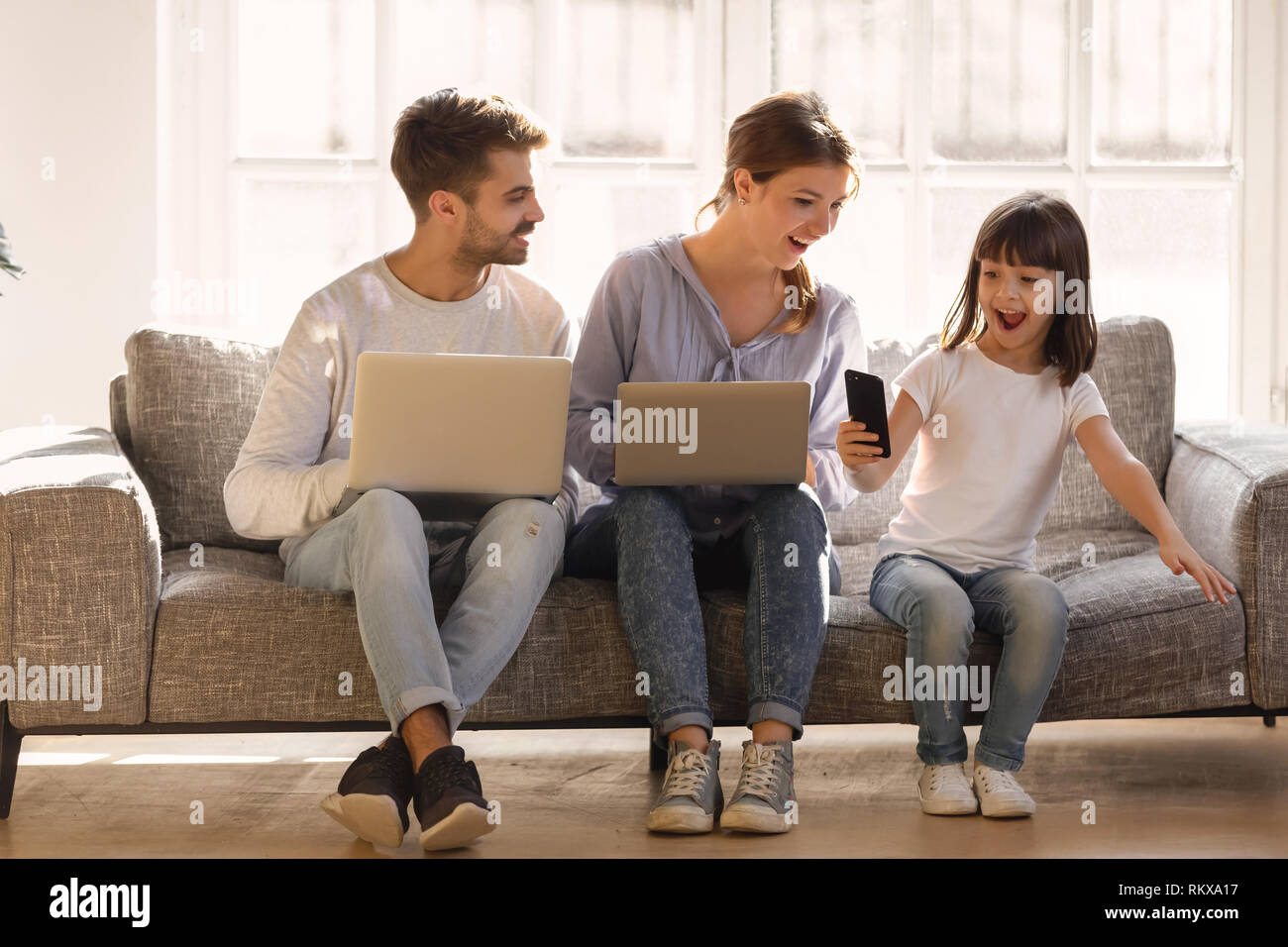 Kind, Mädchen, dass Smartphone mit entsetzten Eltern überraschend App begeistert Stockfoto