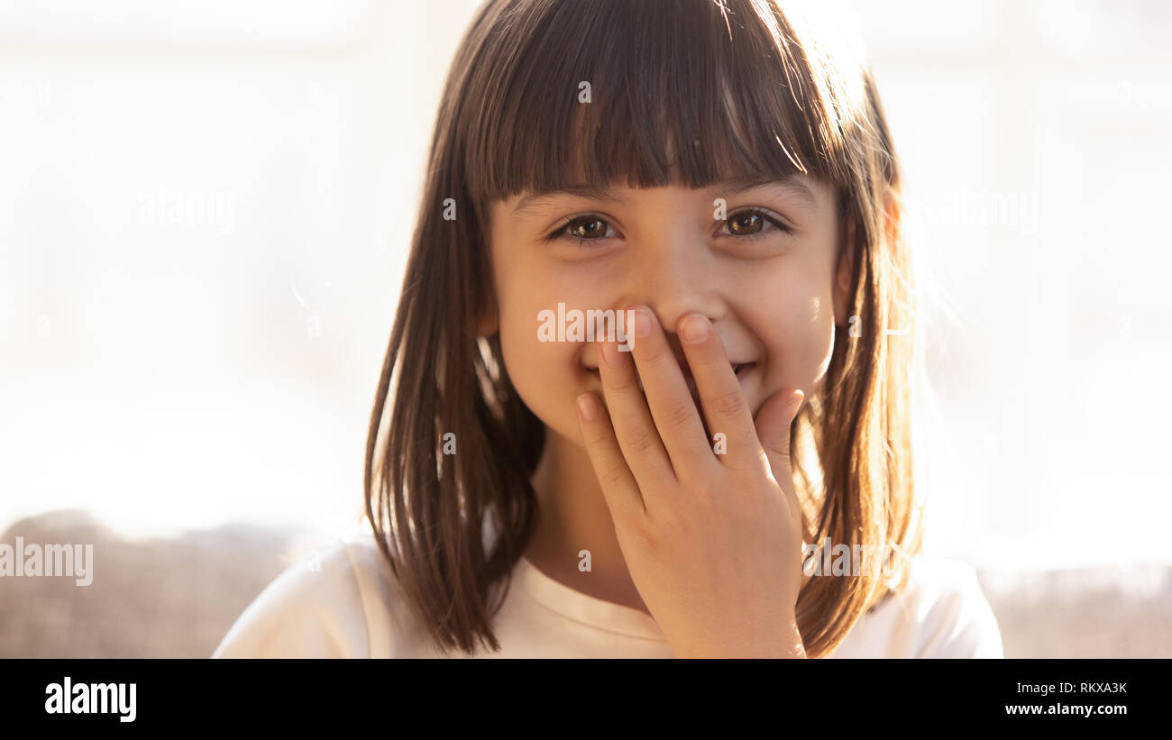 Lustige schüchterne Mädchen lachend über den Mund mit der Hand, headshot Portrait Stockfoto