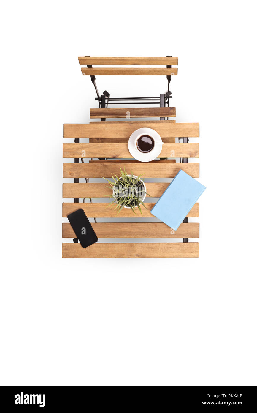 Blick von oben auf einen hölzernen Tisch mit Kaffee, Anlage und Handy und ein Stuhl von oben genommen Stockfoto