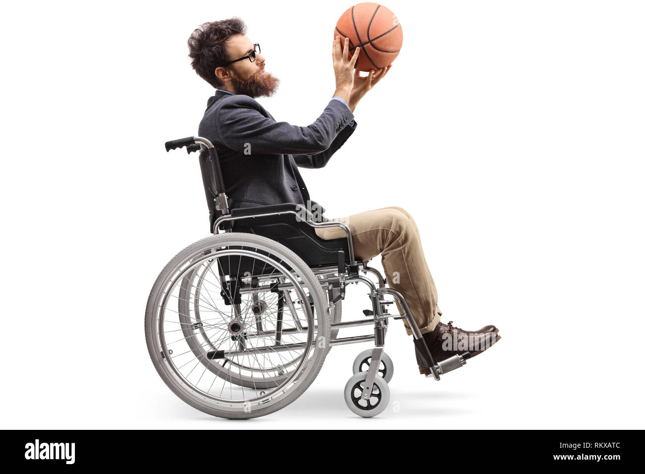 Volle Länge Profil geschossen von einem jungen Mann im Rollstuhl mit einem Basketball auf weißem Hintergrund Stockfoto