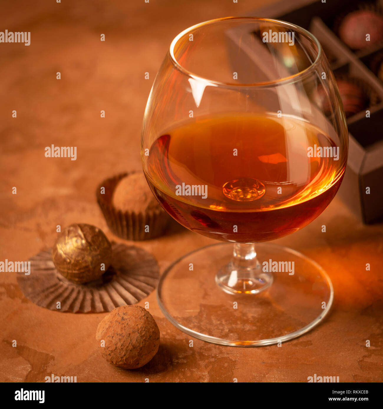 Ein Glas Schnaps und Schokolade Süßigkeiten dunklen Hintergrund.  Alkoholische Getränk und Elite Schokolade essen Konzept. Quadratischen  Rahmen Stockfotografie - Alamy