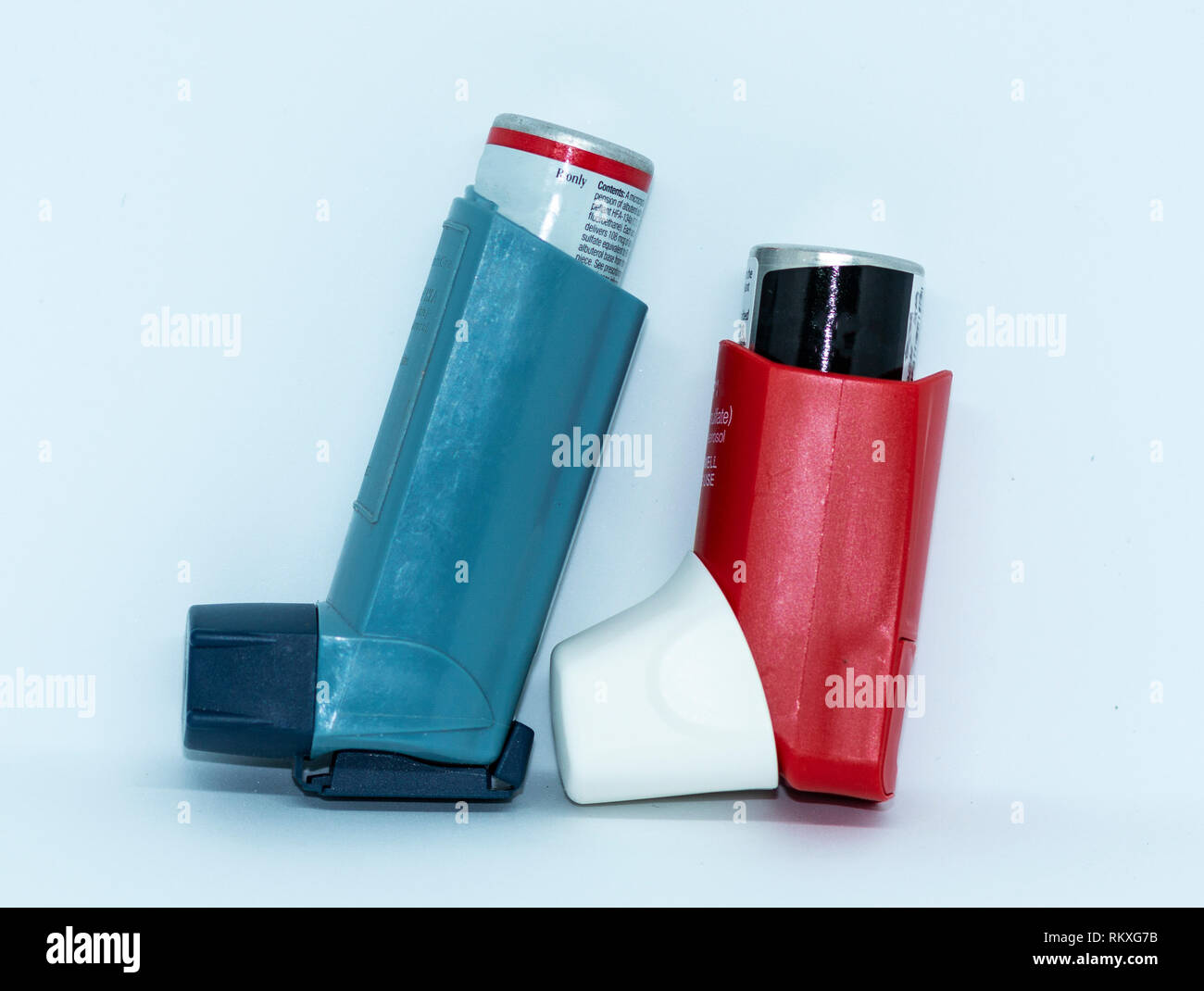 Eine blaue und eine rote Asthma rescue Inhalator steht mit einem weißen Hintergrund. Stockfoto