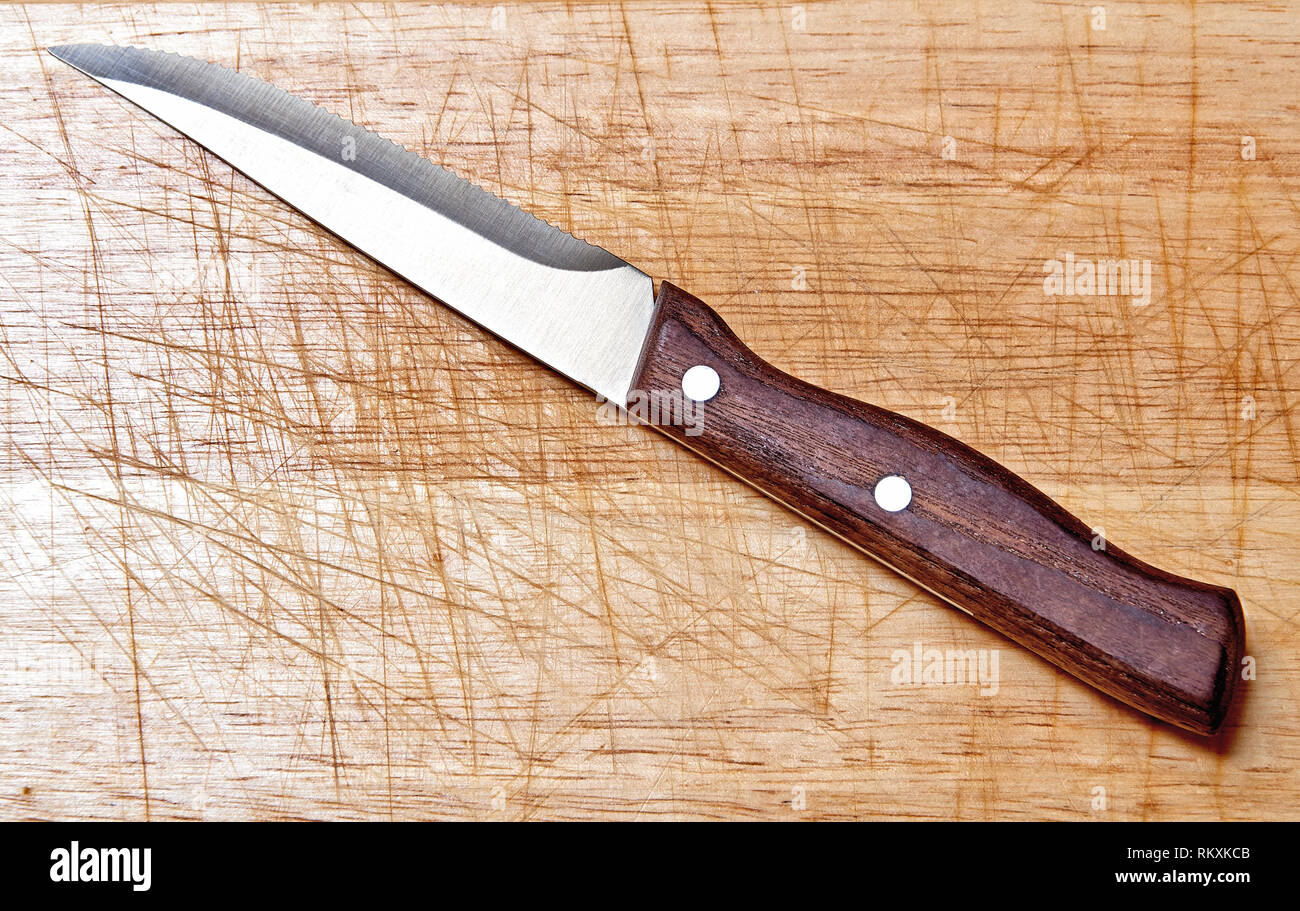 Eine steack Messer auf strukturierte und zerkratzt Holzbrett, Ansicht von oben mit Tageslicht Stockfoto