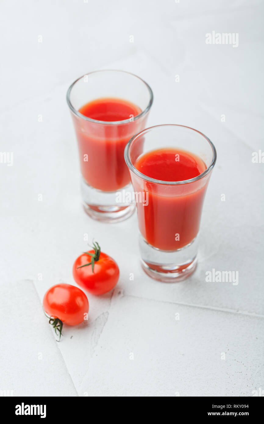 Tomate Bloody Mary würzige Alkohol auf weißem Hintergrund mit kopieren. Cold Bloody Mary cocktail shot in Gläsern und Tomaten. Stockfoto