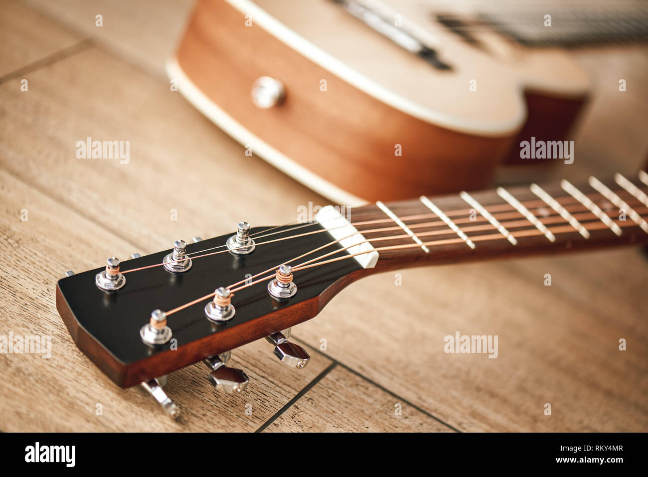 Tuning Sound. Nahaufnahme des Gitarrenhals mit Stimmschlüssel für die Anpassung der Gitarre Saiten liegen auf dem Holzboden. Musikinstrumente. Musik Equipment. Musik Shop Stockfoto