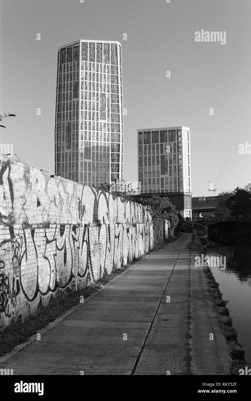 Wand mit Graffiti entlang des Flusses Lea in der Nähe von Bogen, East London, UK, mit der neuen Sky View Tower Apartment Gebäude im Hintergrund Stockfoto