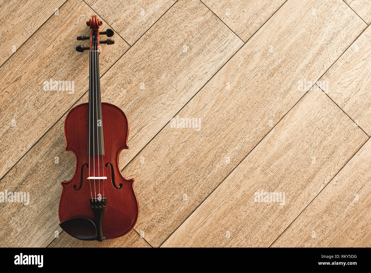 Klassische Musikinstrument. Blick von oben auf die braune Geige liegen auf dem hellen Holzboden. Musikinstrumente. Musik Equipment. Musik Hintergrund Stockfoto