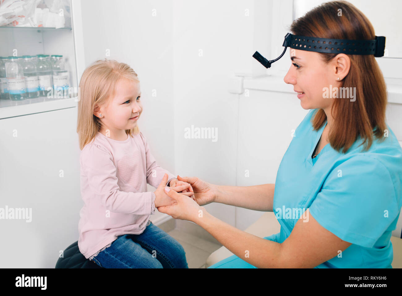 Fröhlich Kinderarzt begrüßt einen kleinen Patienten. Doctor's Holding kind Hand in Komfort Stockfoto