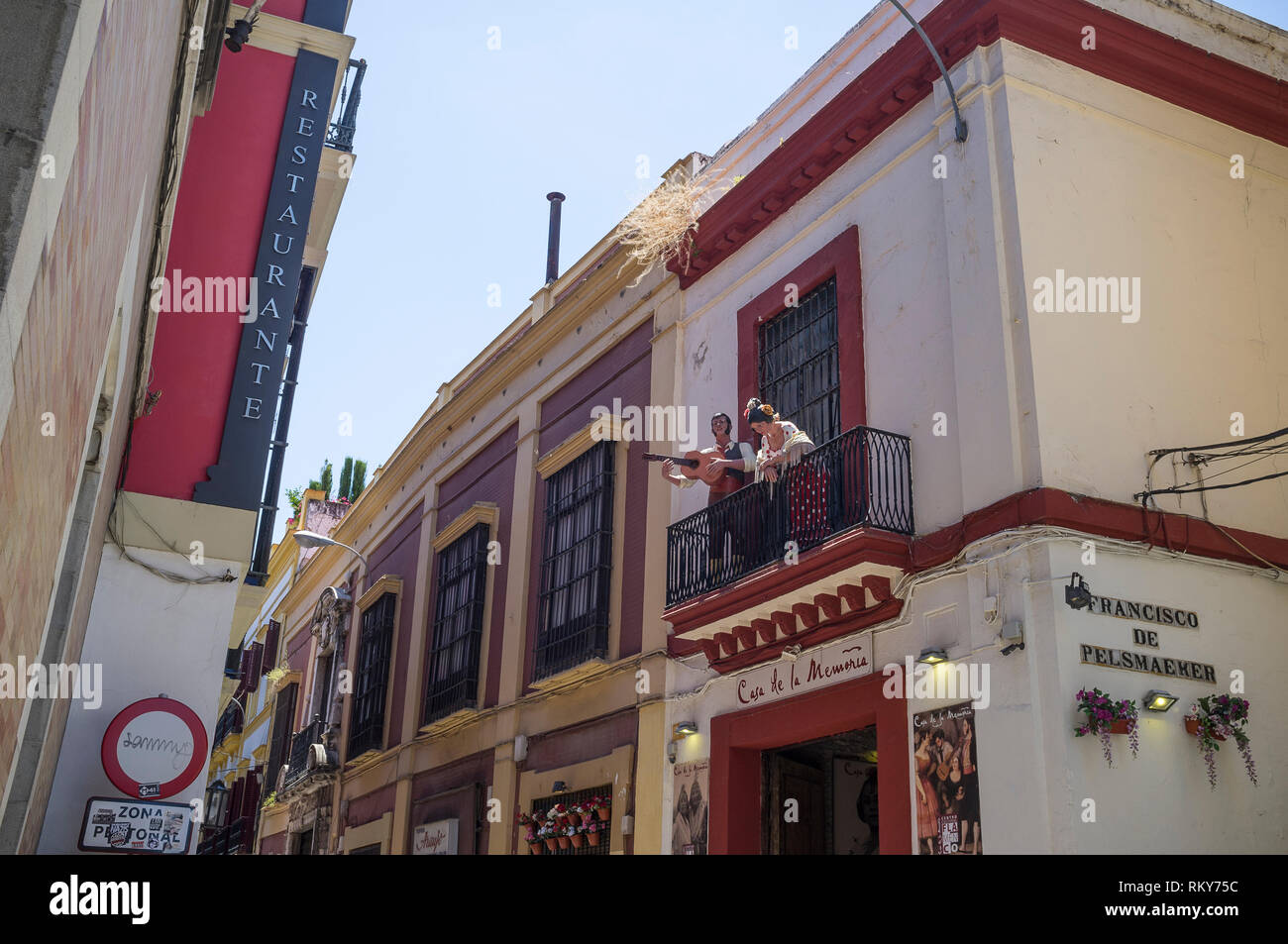 Mannequins eines Mannes, der Gitarre spielt, und einer Frau in Flamenco-Kostümen, die auf dem Balkon eines Geschäfts in Sevilla im ersten Stock posierten. Stockfoto