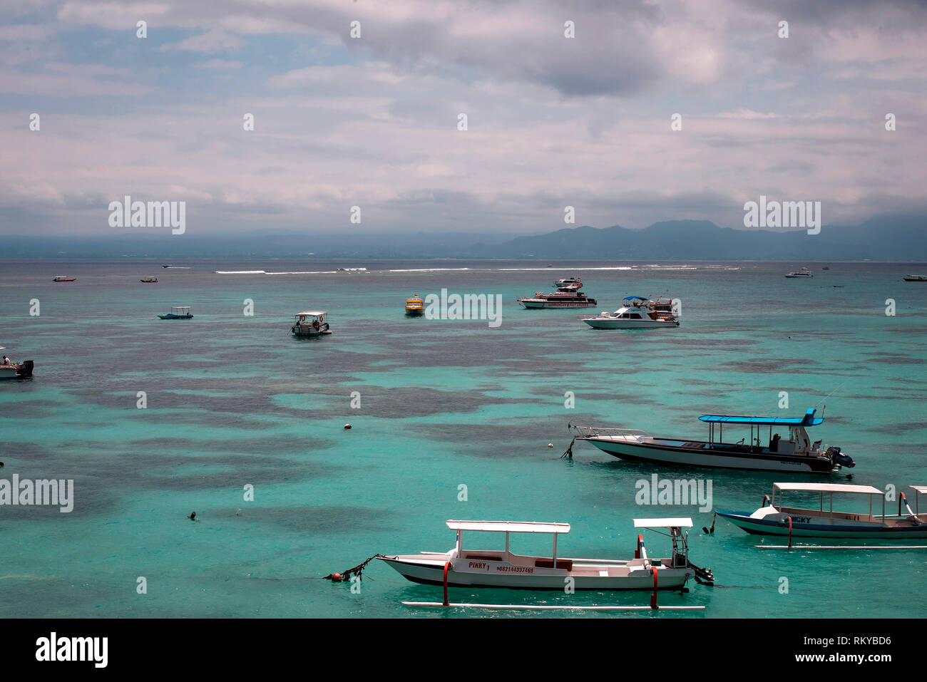 Angelegte Boote in einem azurblauen Bucht von einer tropischen Insel. Stockfoto