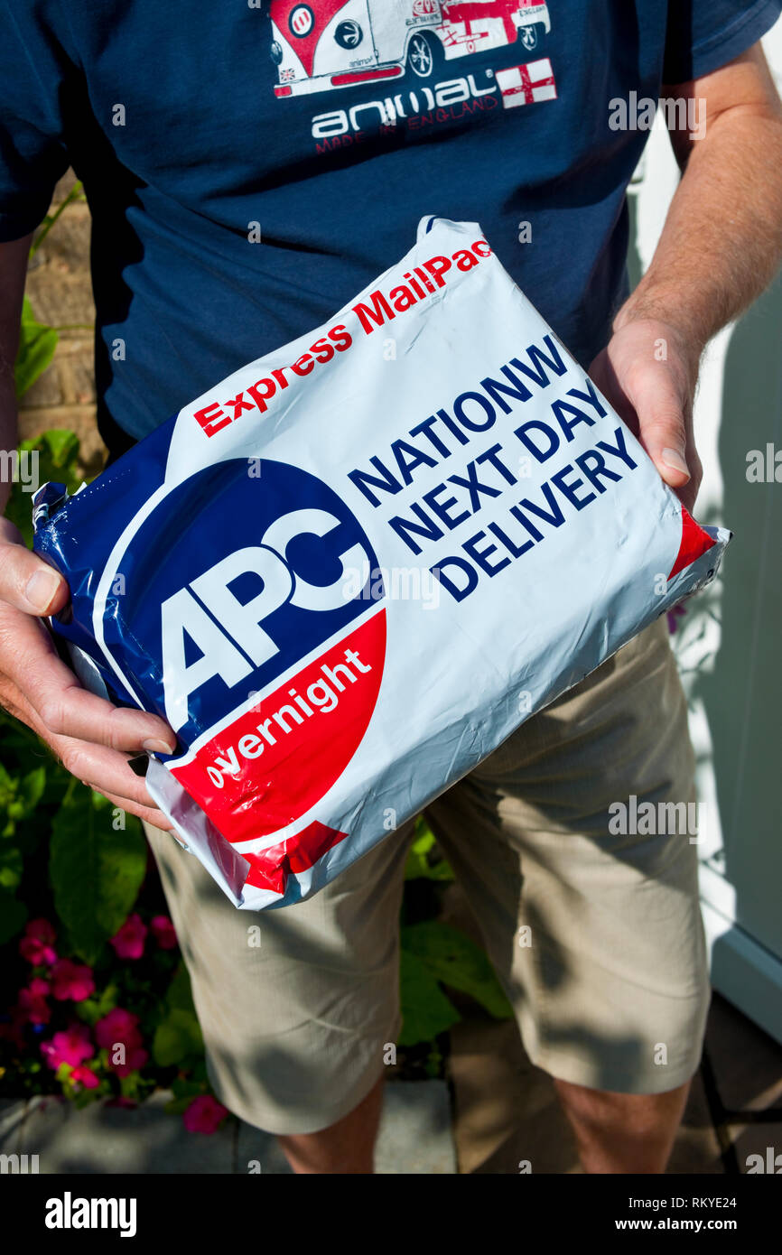 Kurier liefert APC Overnight Express Mail Paket. Stockfoto
