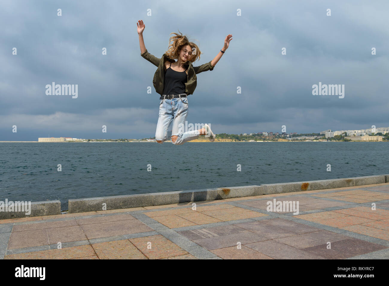 Junge Mädchen in einem sprungwurf gegen das Meer Stockfoto