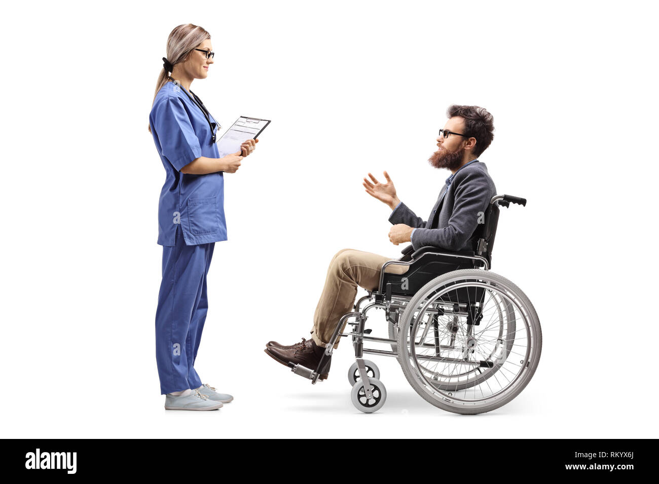 Volle Länge Profil Schuß einer jungen weiblichen Krankenschwester in einem Gespräch mit einem bärtigen Mann im Rollstuhl auf weißem Hintergrund Stockfoto