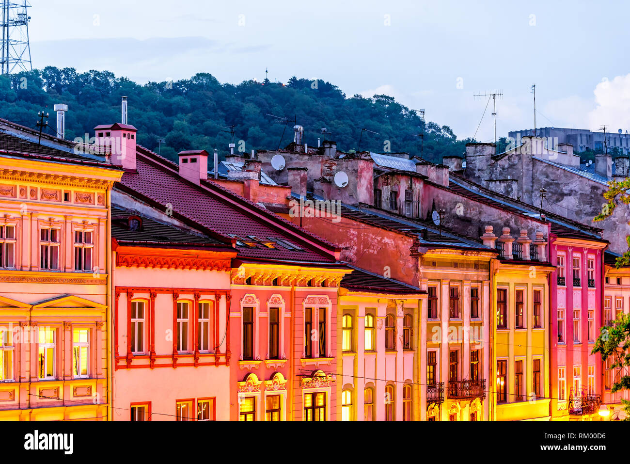 Historische Lviv, Ukraine Stadtbild Exterieur mit bunten Orange Gebäude der Marktplatz in der Altstadt am Abend Nacht rot rosa beleuchtet Stockfoto