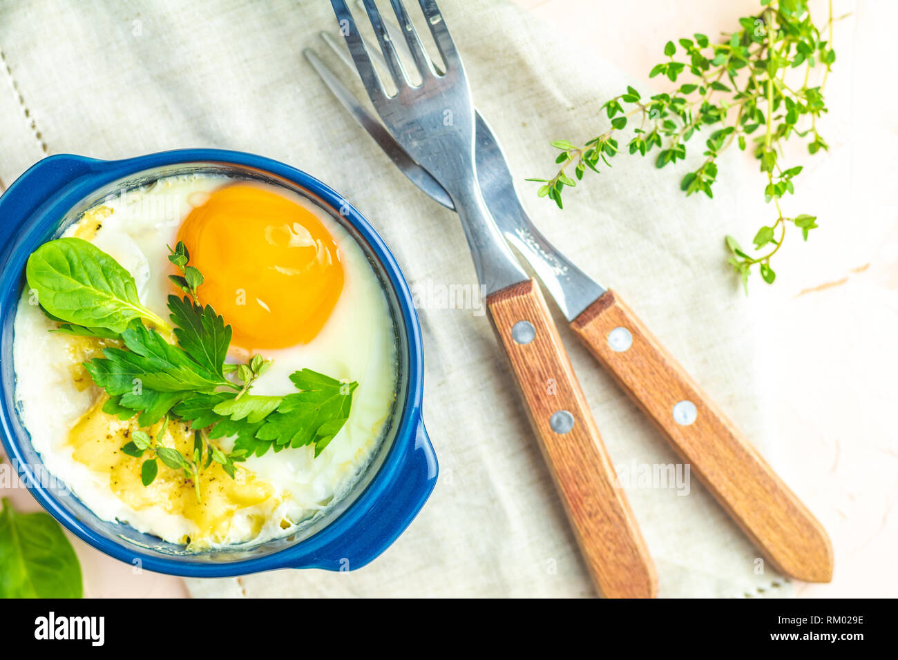 Eier kokot Cocotte französisches Frühstück. Gebackene Eier in blau Keramik Backformen. Portioniert Auflauf aus Gemüse und Eier im italienischen Stil. Stockfoto