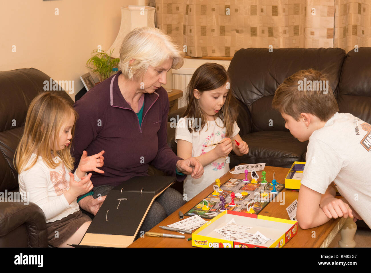 Großmutter, Oma, spielen Brettspiel mit drei Enkelkindern im Alter von