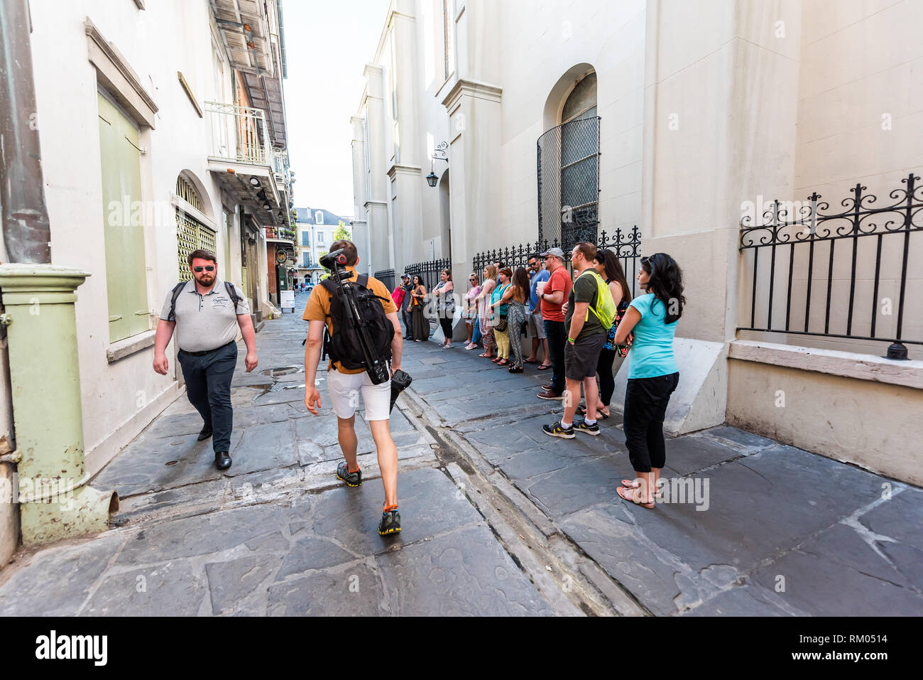 New Orleans, USA - 23. April 2018: Altstadt Straße in Louisiana berühmte Stadt mit vielen glücklichen Menschen zu Fuß auf der Straße durch den Bau der Wand Tour Gruppe Stockfoto