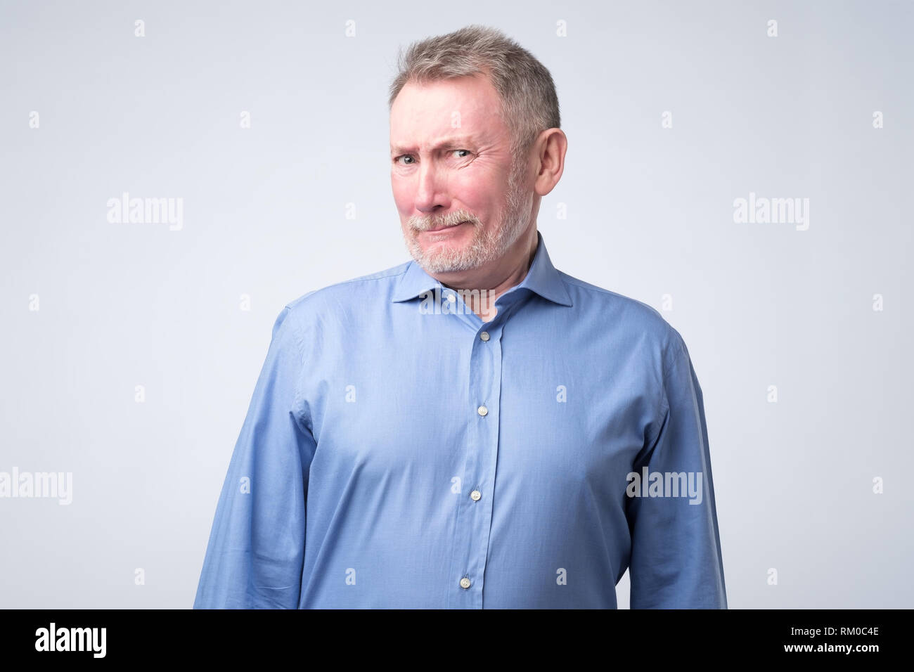 Älterer Mann im blauen Hemd suchen mit Unglauben Ausdruck. Stockfoto