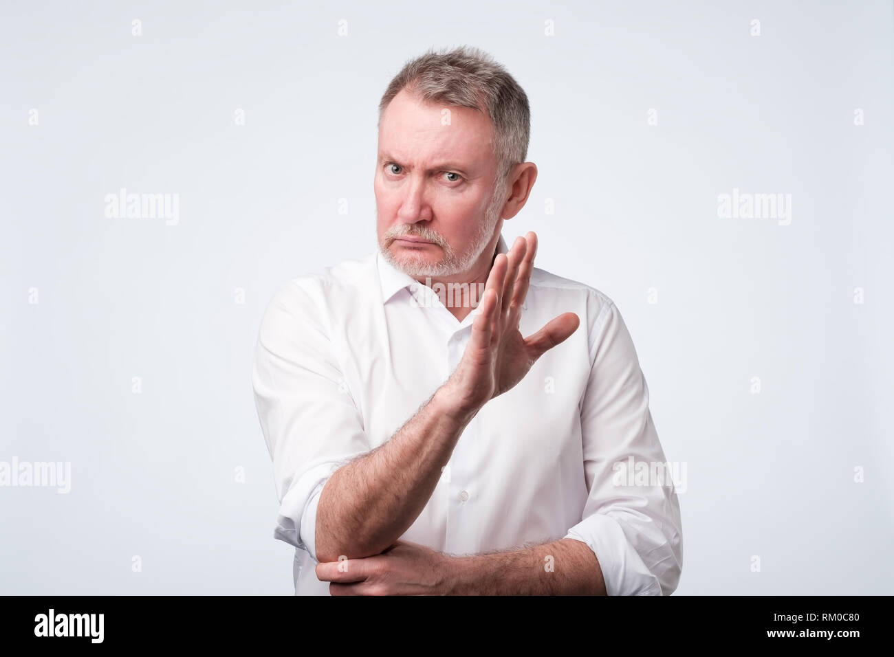 Gut aussehender älterer Mann, STOP-Schild. Negative facial Emotion Stockfoto