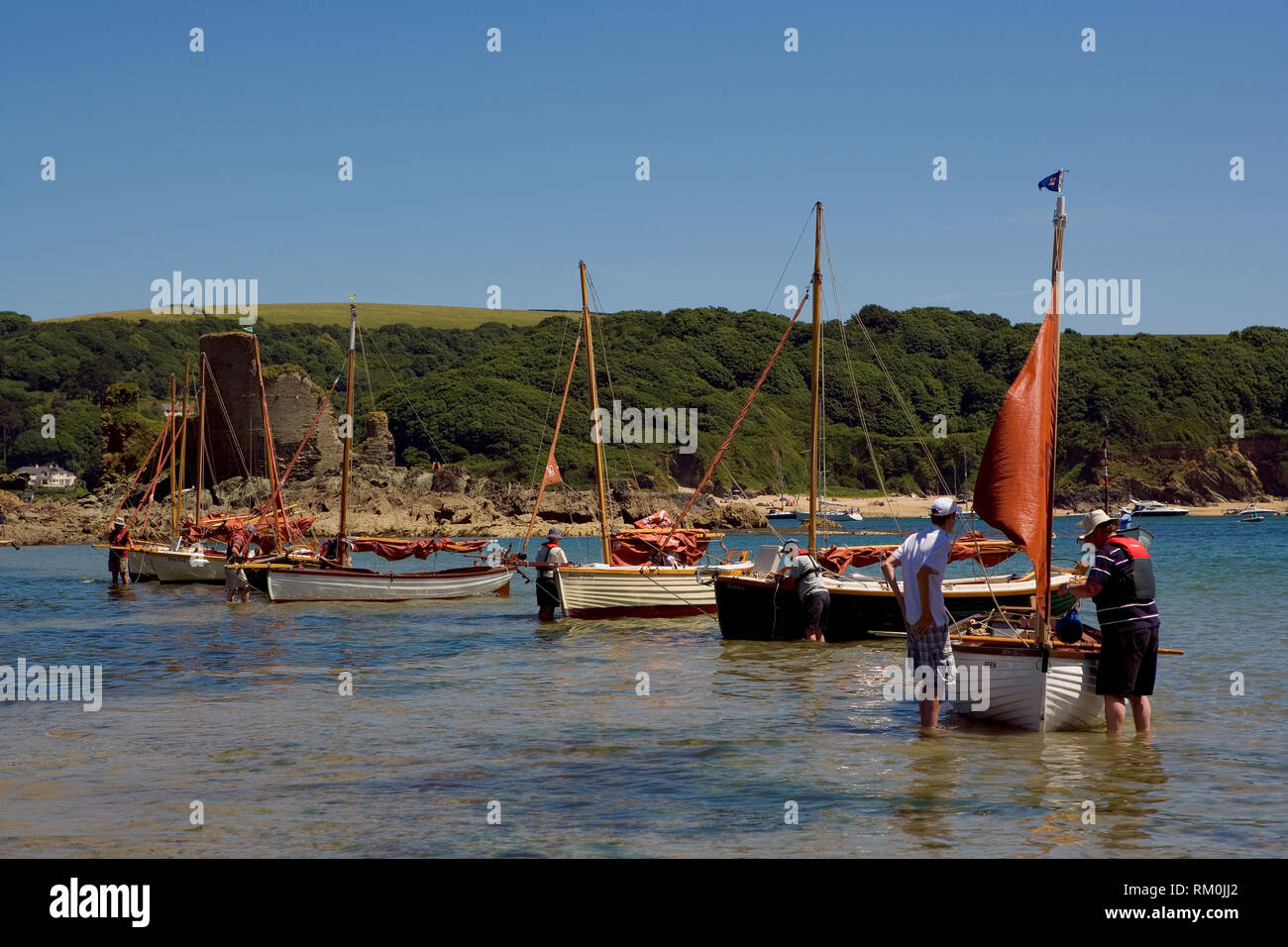 Ein yacht Vorbereitung auf Rennen in North Sands in Kingsbridge. Fort Charles ist im Hintergrund sichtbar. Stockfoto