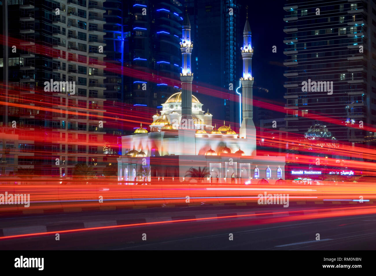 Die alten und modernen kollidieren in der futuristischen Stadt Dubai als Verkehr wirbelt Vergangenheit einer der vielen Moscheen. Stockfoto