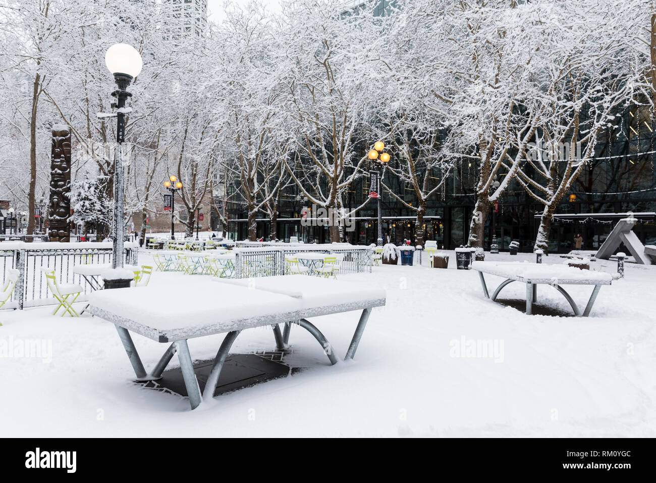 Seattle, Washington: Tischtennisplatten in der abendländischen Square ungenutzte Sitzen als starker Wintersturm decken die Stadt in sechs Zentimeter Schnee. Stockfoto