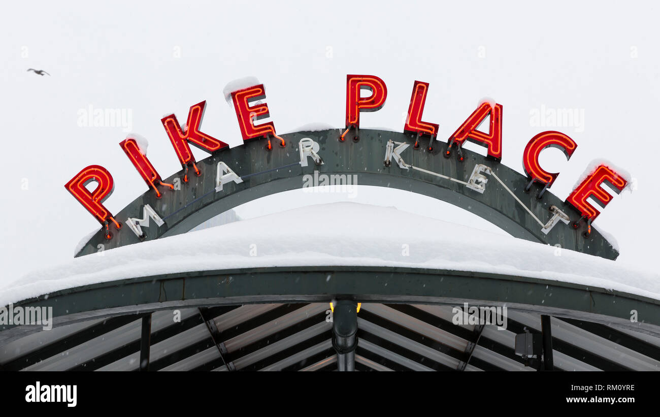 Seattle, Washington: Neon bus Pike's Place Market stop-Schild wird mit frischem Schnee Bestäubt als starker Wintersturm decken die Stadt. Stockfoto
