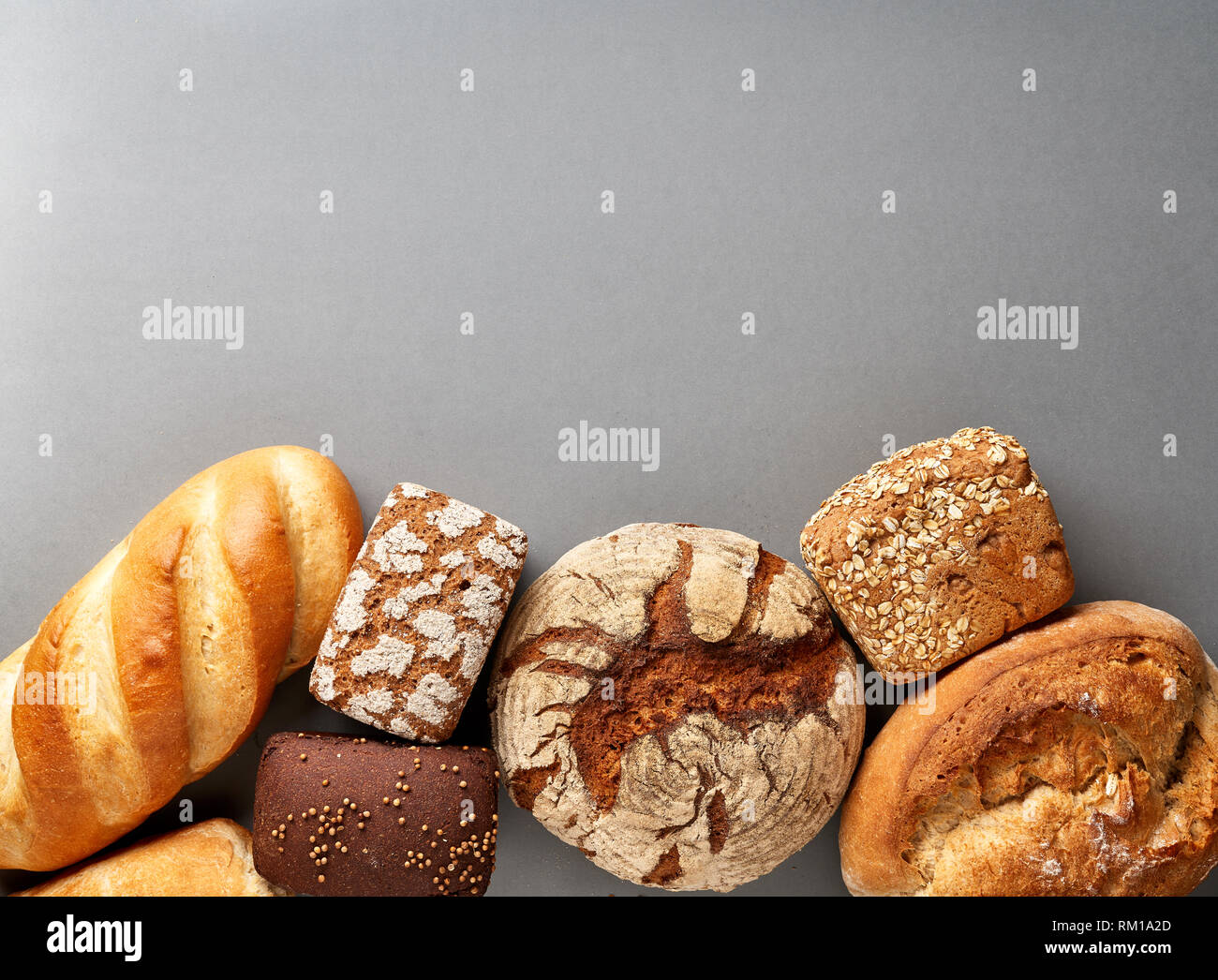 Sortiment gebackene Brot auf grauem Hintergrund mit leeren Platz für Text und ihrem Design. Stockfoto