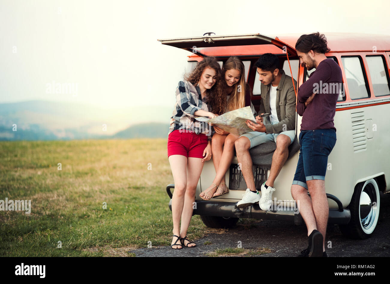 Eine Gruppe junger Freunde auf einem Roadtrip durch Land, auf Karte suchen. Stockfoto