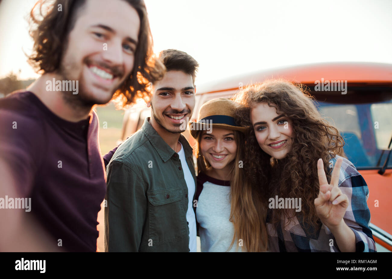 Eine Gruppe junger Freunde auf einem Roadtrip durch Landschaft, wobei selfie. Stockfoto