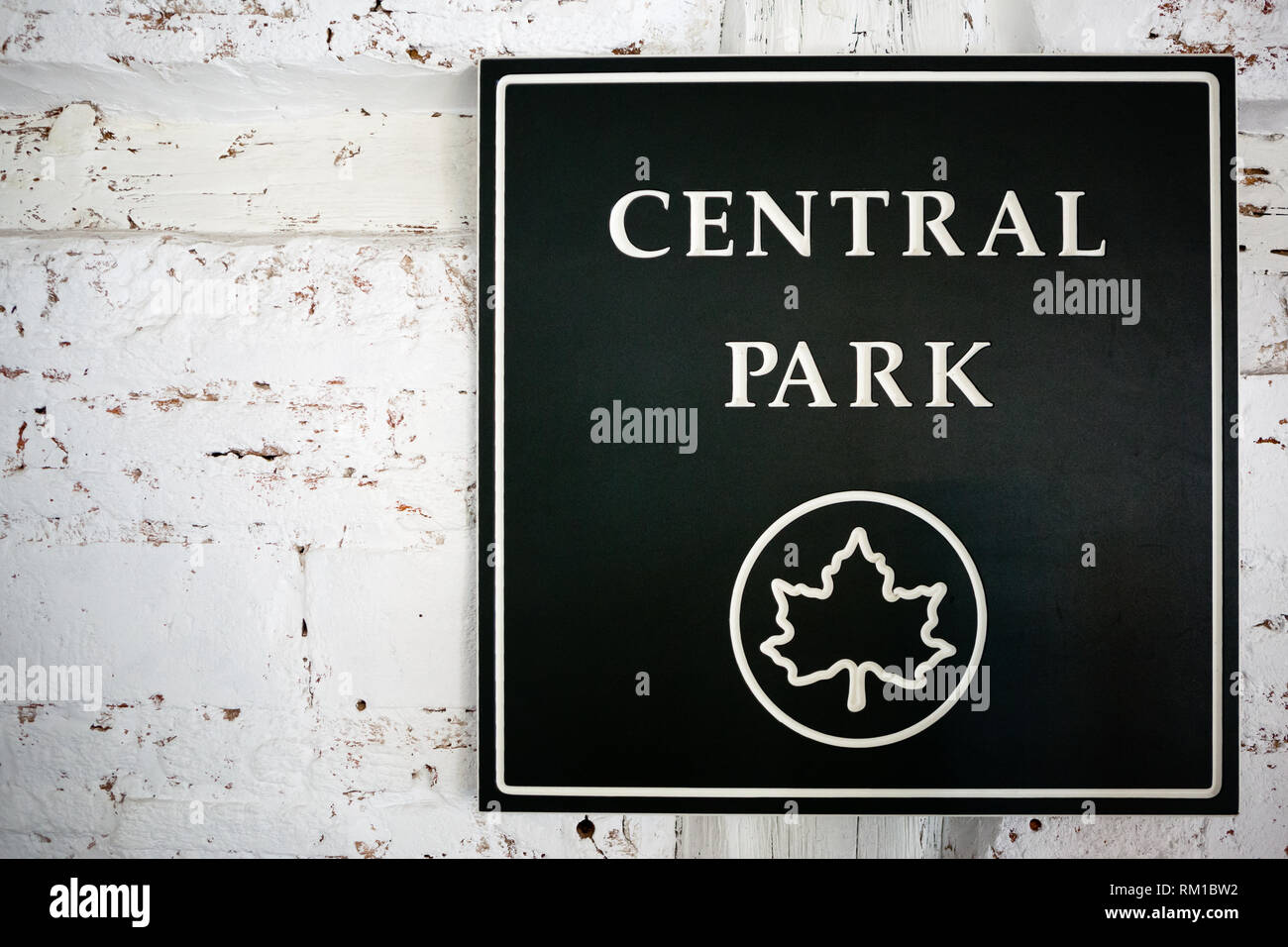 Eine weiße alte Mauer mit dunkelgrünem Schild des Zentralparks Stockfoto