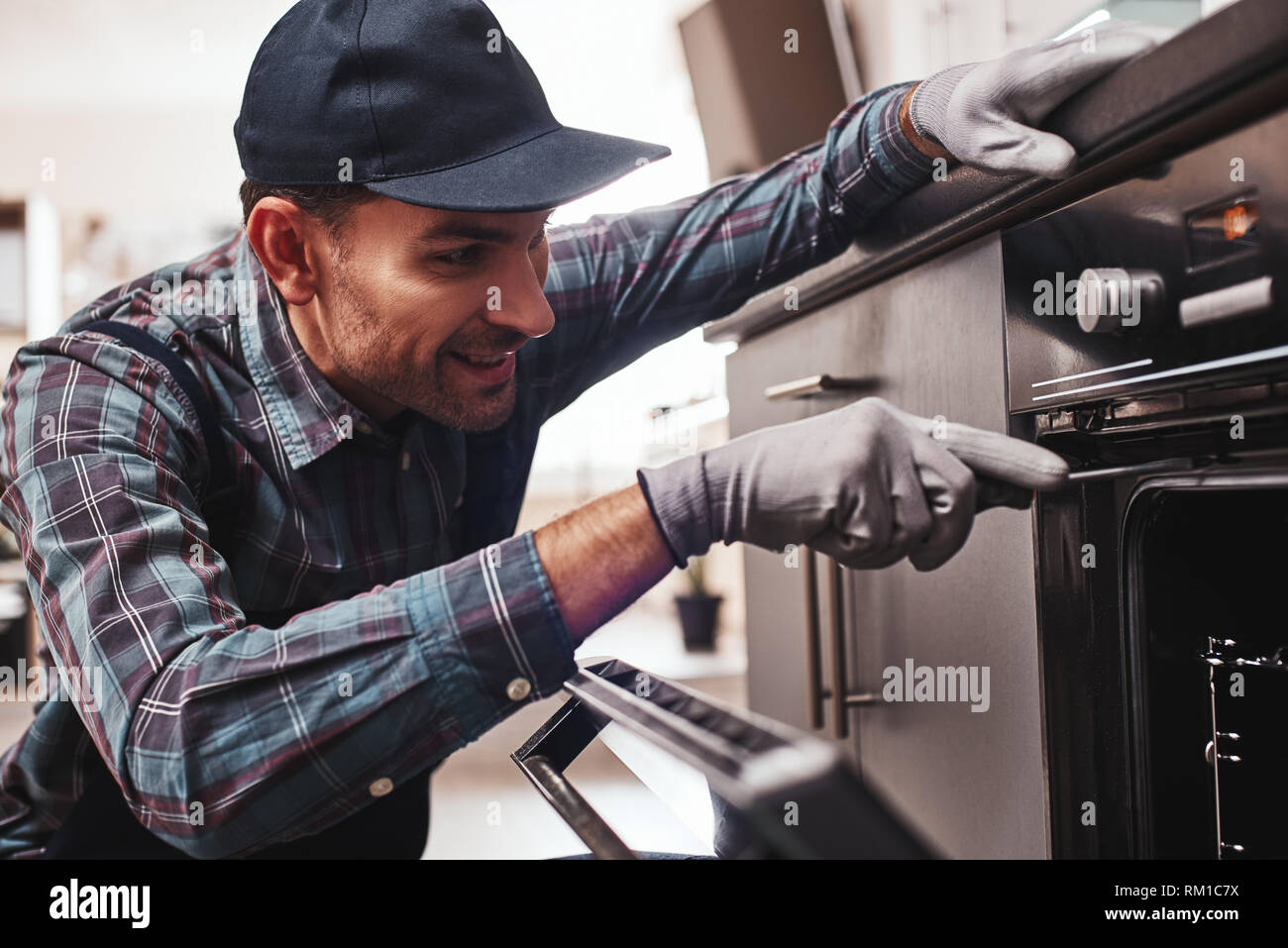Nicht mit der Reparatur verzögern. Nahaufnahme der reparateur Backofen Prüfung mit einem Schraubendreher in der Küche im Koffer Stockfoto