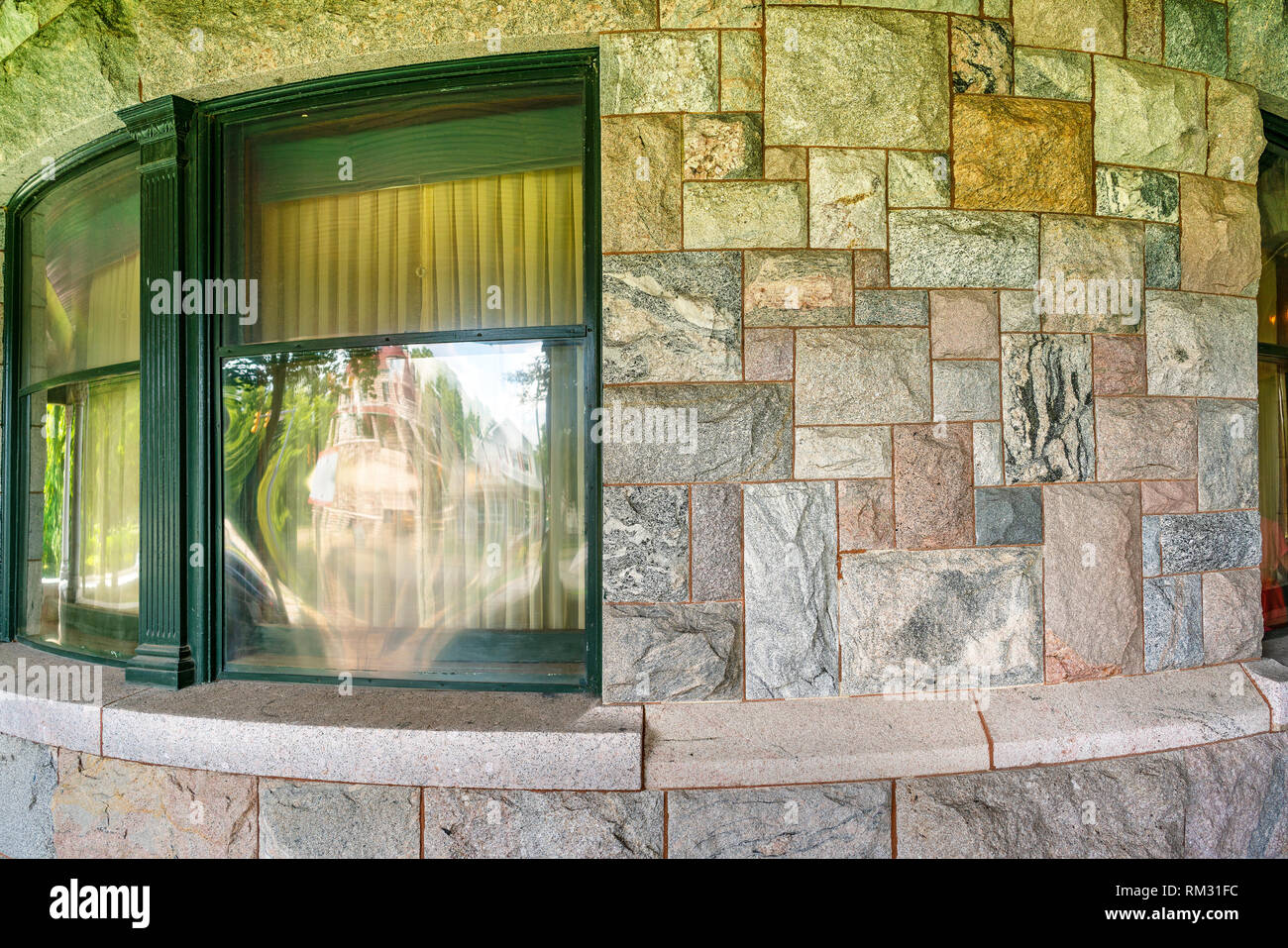 Gebogene Mauer aus Stein mit Fenster Reflexion Stockfoto