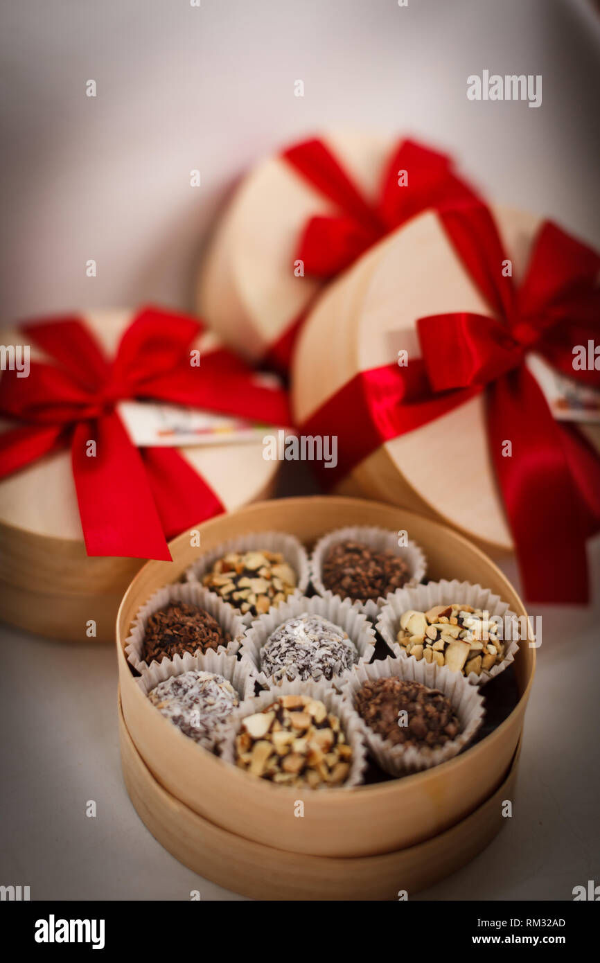 Nahaufnahme der besondere Schokolade Bonbons in runde Schachteln mit roten Bändern umwickelt Stockfoto