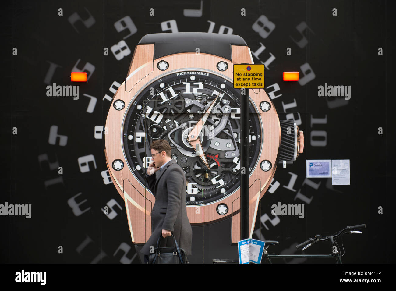 Mayfair, London, Großbritannien. 13. Februar, 2019. Kein stoppen jederzeit Straßenschild vor einem riesigen armbanduhr Zifferblatt in der Bond Street. Credit: Malcolm Park/Alamy Leben Nachrichten. Stockfoto