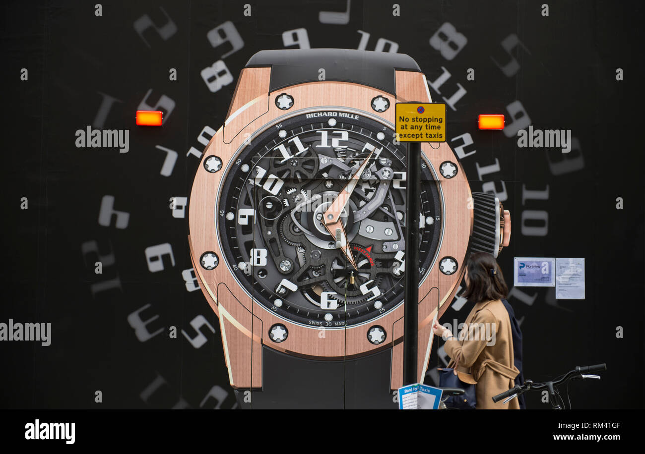 Mayfair, London, Großbritannien. 13. Februar, 2019. Kein stoppen jederzeit Straßenschild vor einem riesigen armbanduhr Zifferblatt in der Bond Street. Credit: Malcolm Park/Alamy Leben Nachrichten. Stockfoto
